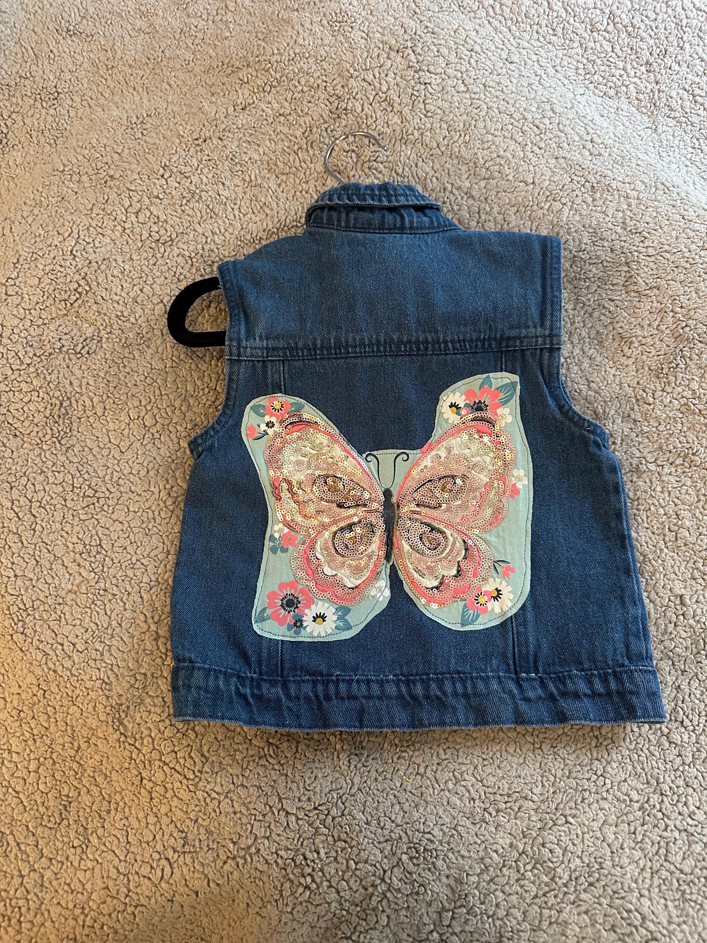 Denim vest with butterfly glitter on back with pink bows on front