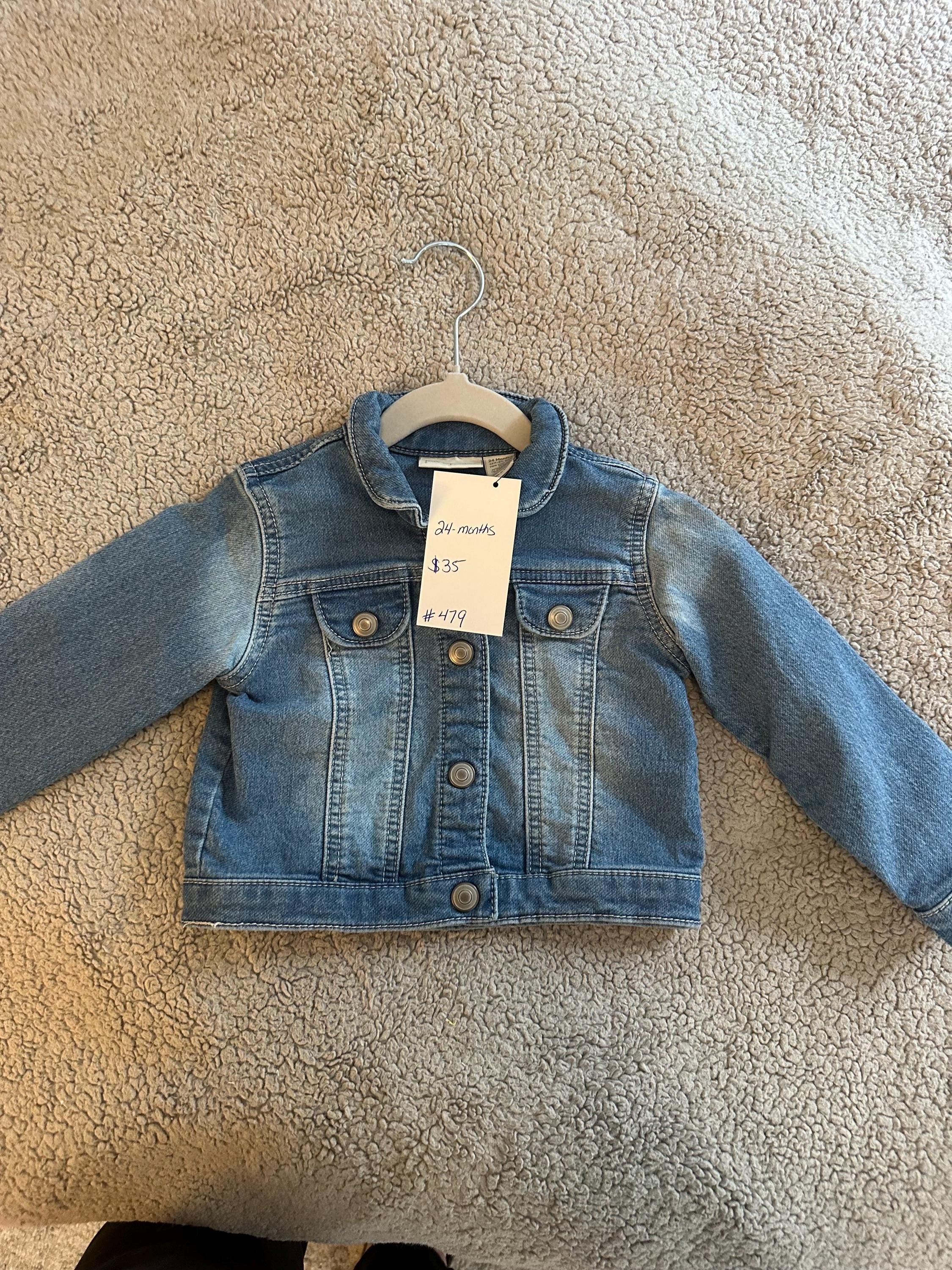 A loader and dump truck on back of denim jacket